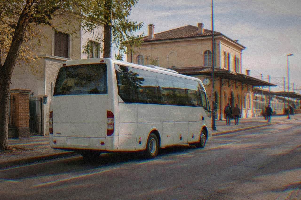 A shuttle bus parked on a street in Ravenna near the railway station