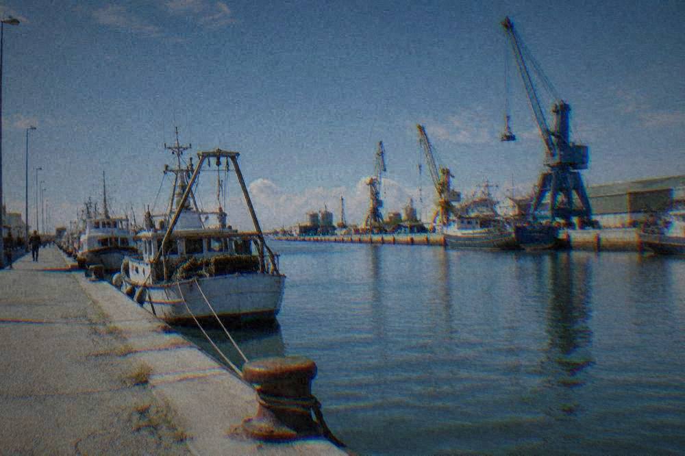The canal at Porto Corsini with port cranes and moored boats along the quay