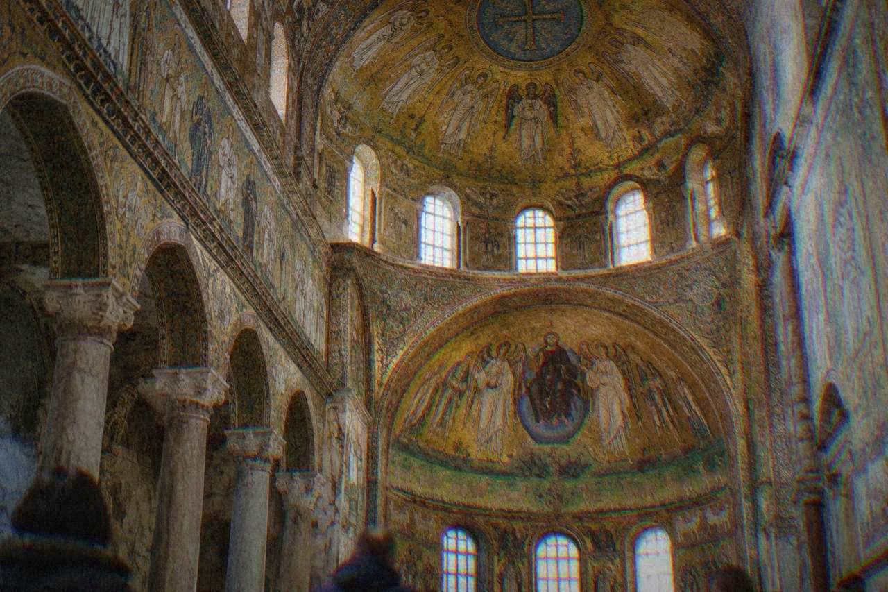 Golden Byzantine mosaics covering the dome and walls of an ancient Ravenna church interior