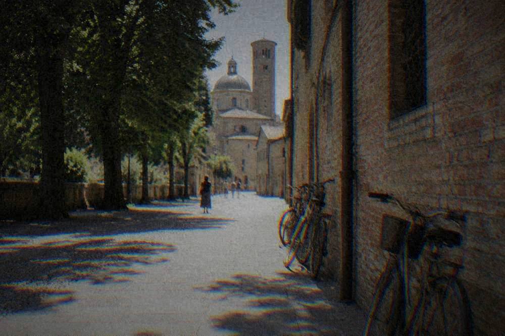 A quiet pedestrian street in Ravenna's historic centre with bicycles leaning against an old brick wall