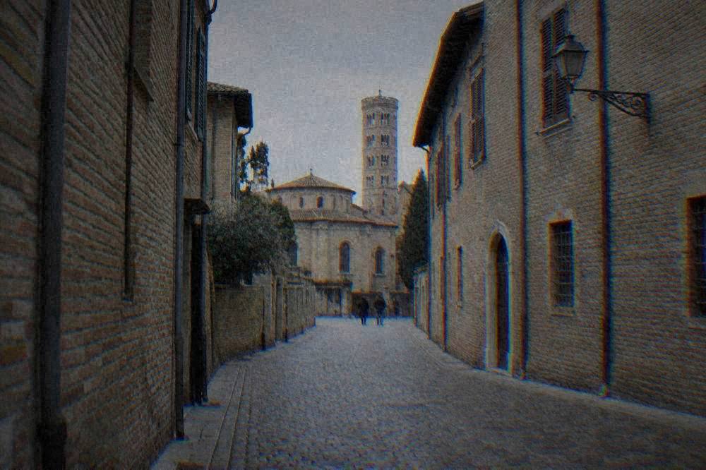 A quiet cobbled street in Ravenna's historic centre lined with old brick buildings