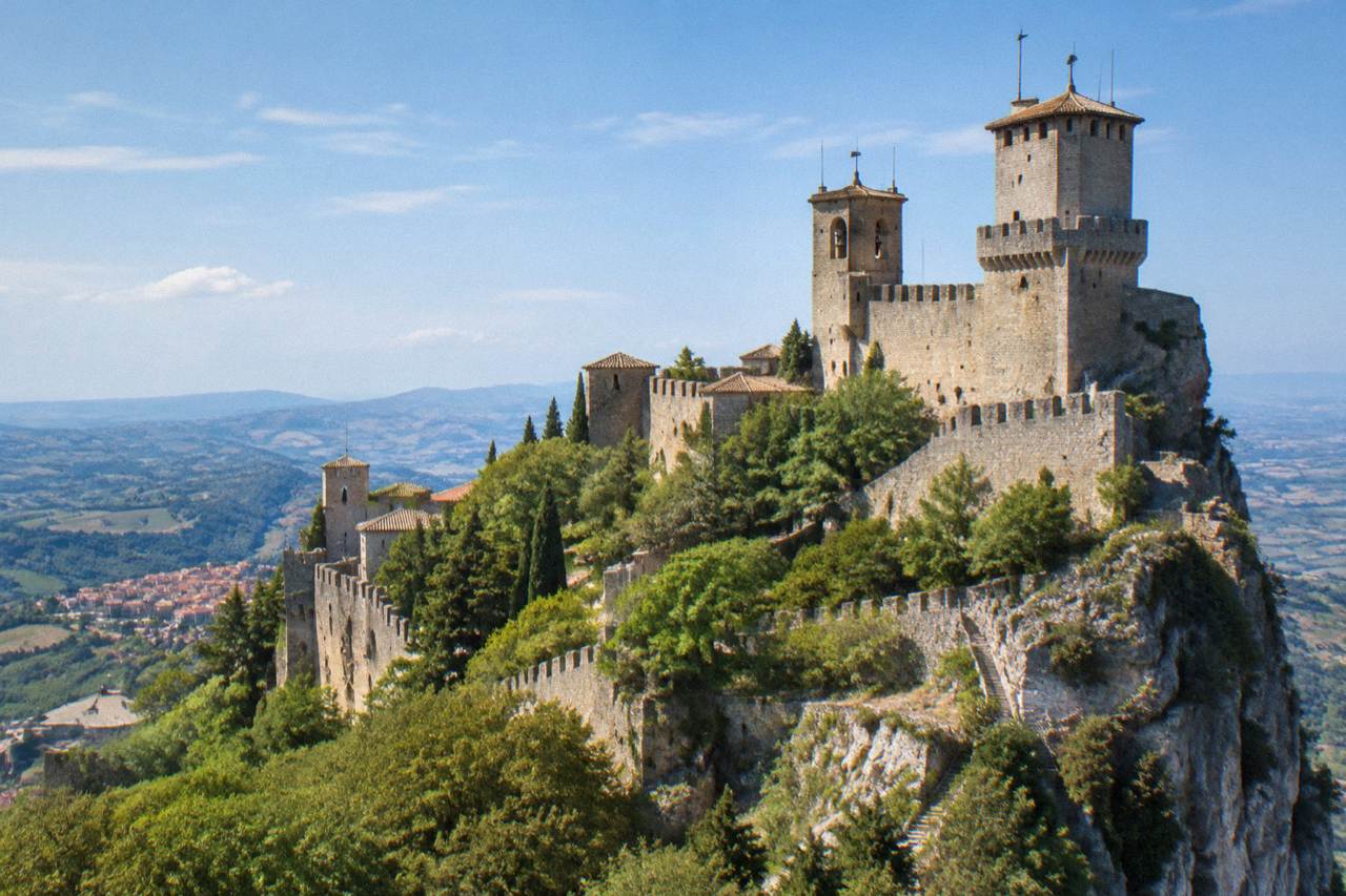 Stone towers on a mountain ridge above hills in the San Marino republic