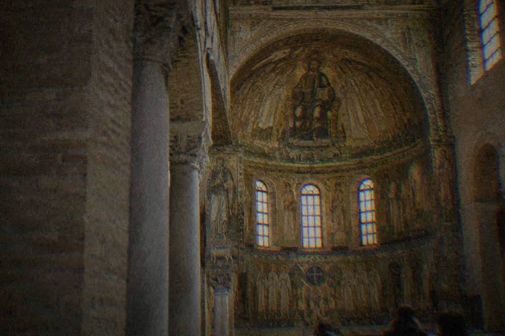 A historic Italian theatre interior with red seating and a lit stage