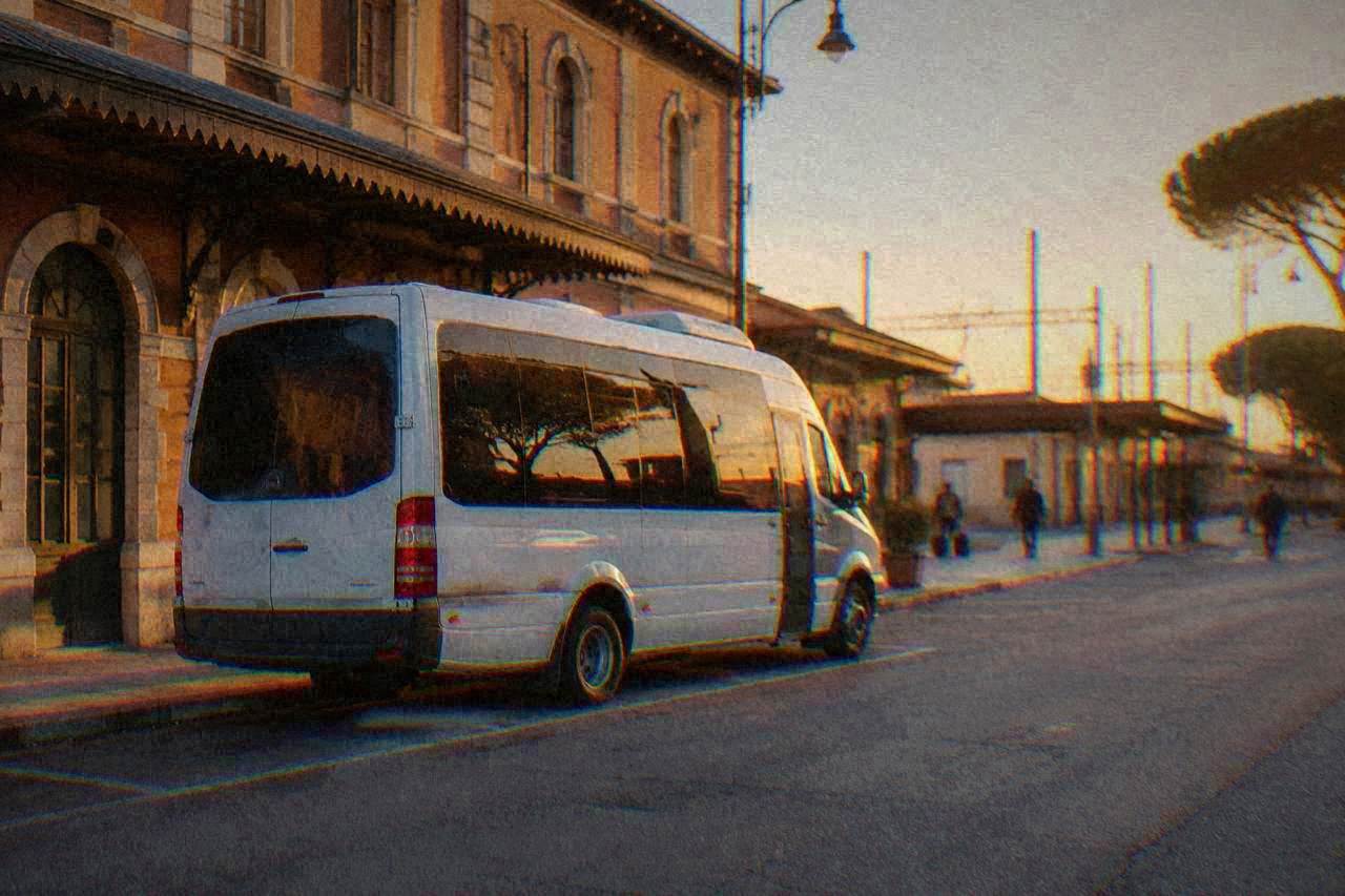 A shuttle bus parked on a quiet street in Ravenna near the railway station