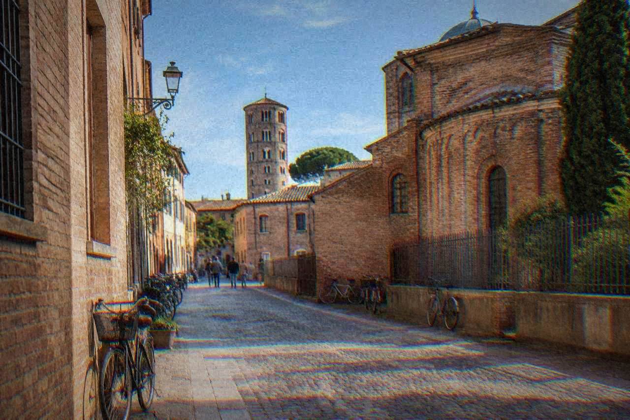 Cobbled street in Ravenna's historic centre lined with old brick buildings and bicycles