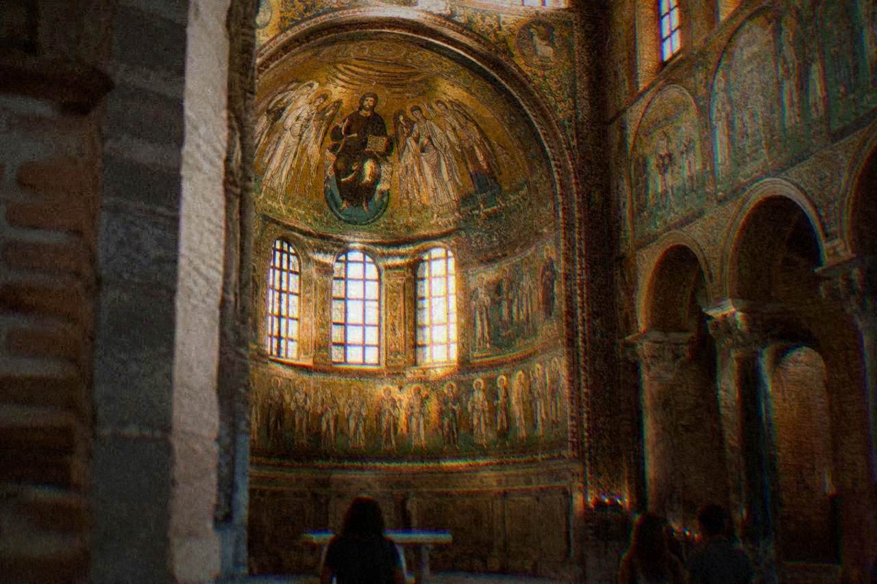 A gilded Byzantine mosaic interior glowing inside an ancient brick church in Ravenna