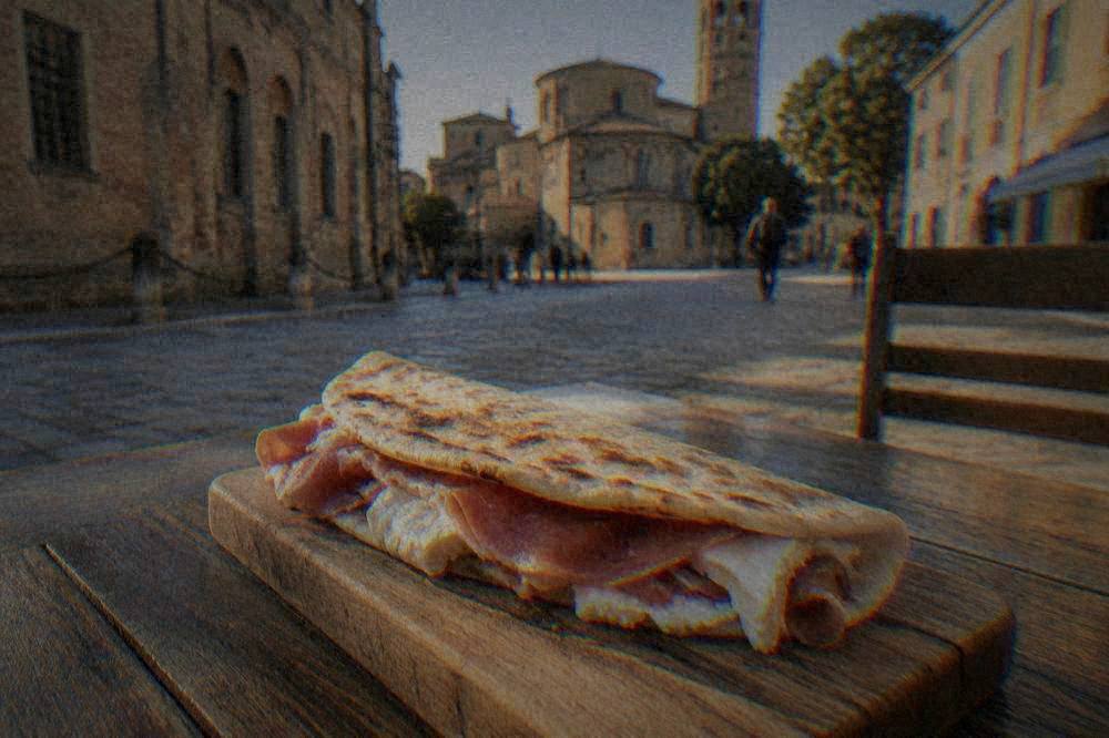 A folded flatbread filled with soft cheese and cured ham on a wooden board