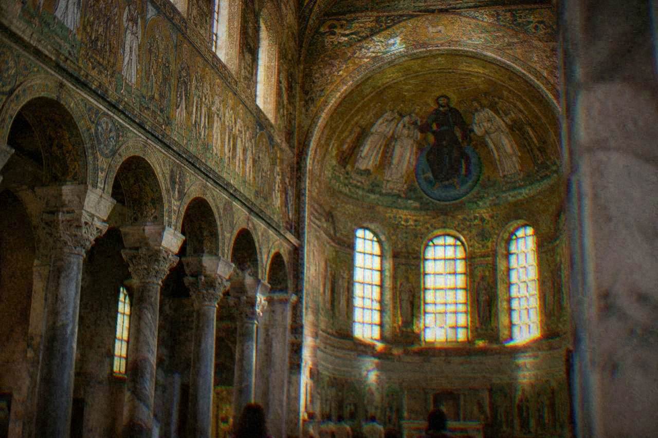 Golden mosaic interior of an early Christian church in Ravenna with intricate wall decorations