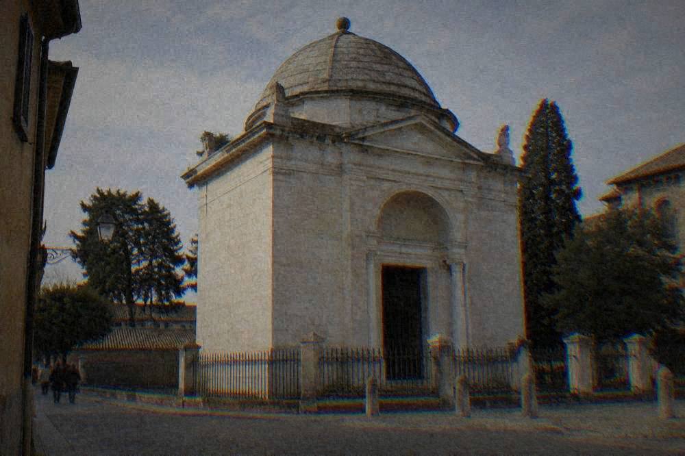 The plain stone exterior of Dante's tomb in Ravenna seen from the street