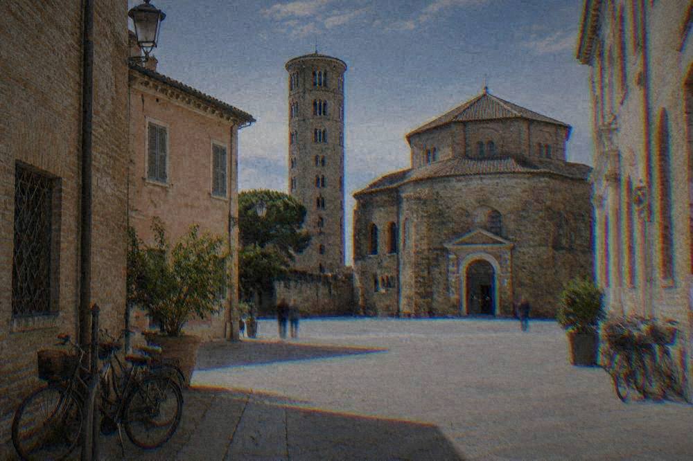 A quiet paved square in Ravenna's historic centre with brick facades and bicycles