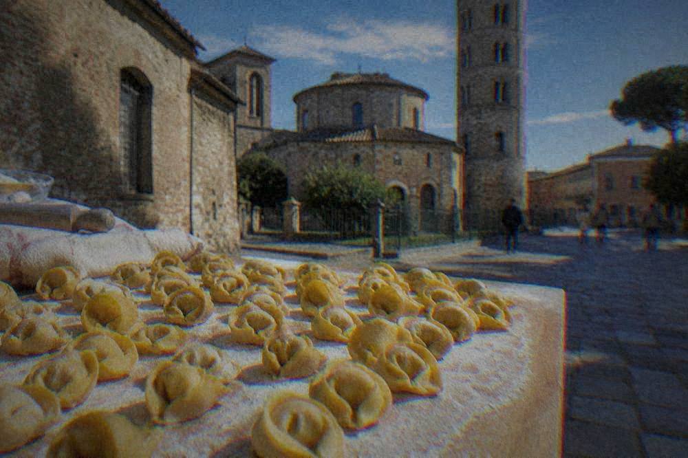 Freshly made cappelletti pasta arranged on a floured wooden board