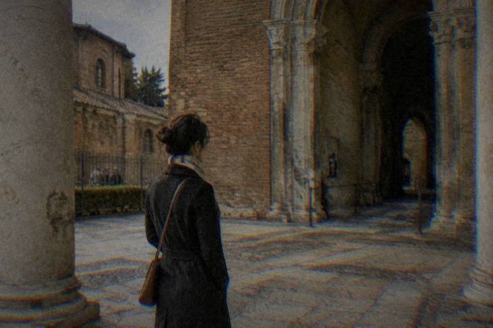 A visitor buying tickets at a monument ticket desk in Ravenna