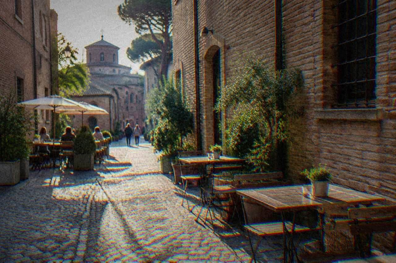 A quiet Ravenna side street in the historic centre with small eateries and tables near old brick facades