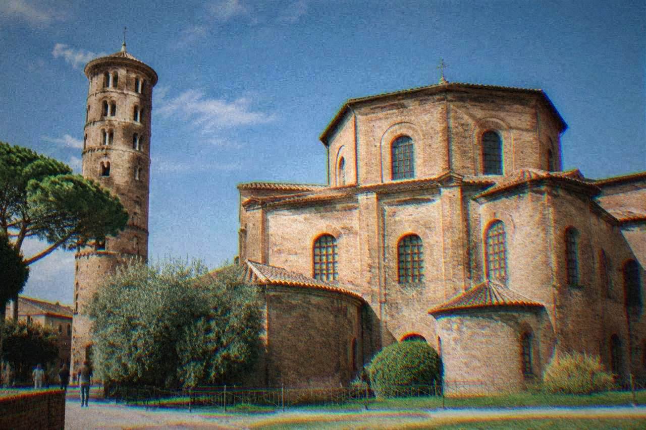 The brick exterior and bell tower of the Basilica of San Vitale in Ravenna under a clear sky