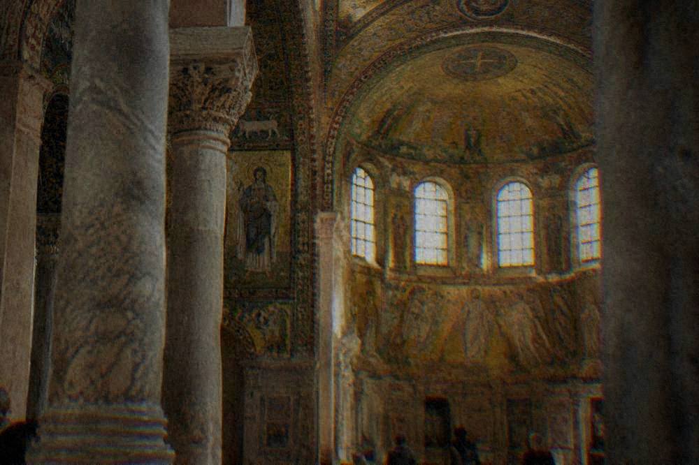 Golden mosaic figures and marble columns inside the Basilica of San Vitale