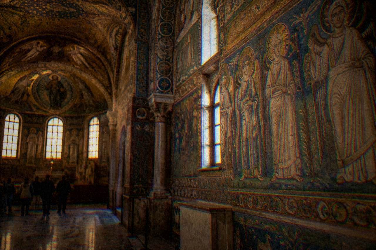 A dimly lit ancient chapel interior with walls and vault covered in gold and blue glass mosaic figures