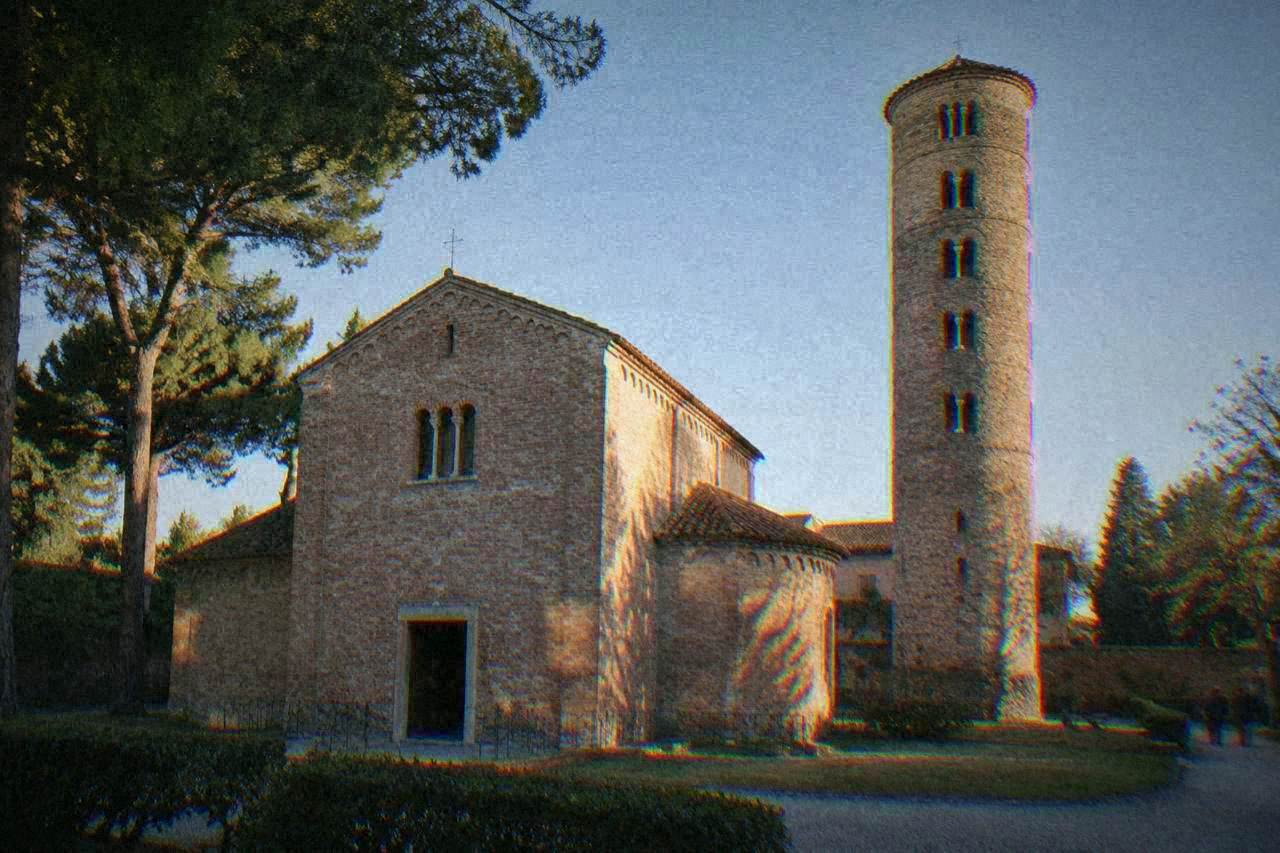 The brick exterior of a small domed chapel standing in a quiet courtyard in Ravenna