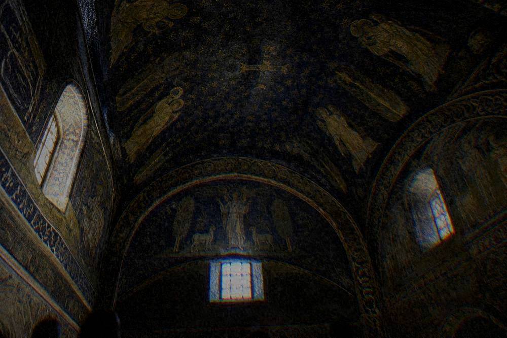 A vaulted ceiling covered in blue and gold mosaic with a star pattern above small windows