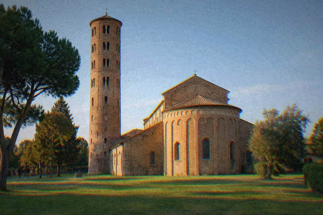 The brick bell tower and apse of the Basilica of Sant'Apollinare in Classe seen across a green lawn