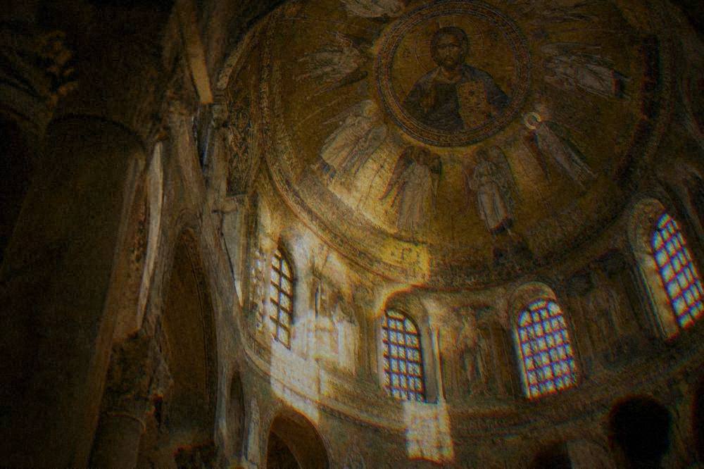 The golden mosaic interior of a Byzantine church dome in Ravenna lit softly