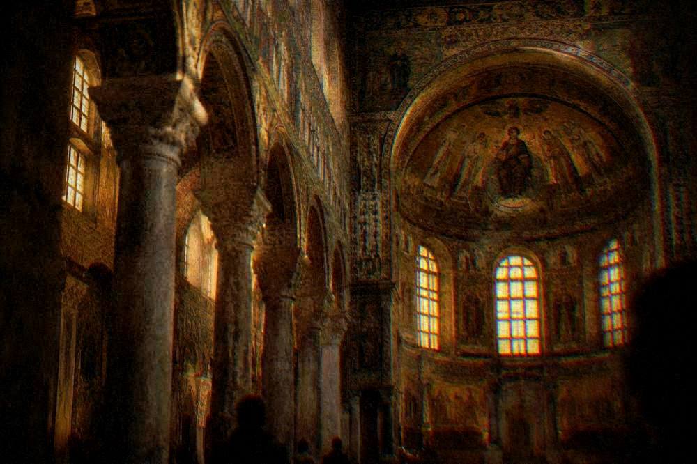 A mosaic-covered church interior glowing under warm evening light in Ravenna
