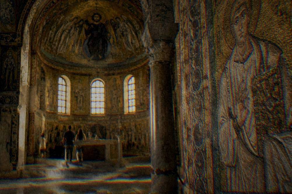 A golden mosaic interior of an ancient chapel lit softly