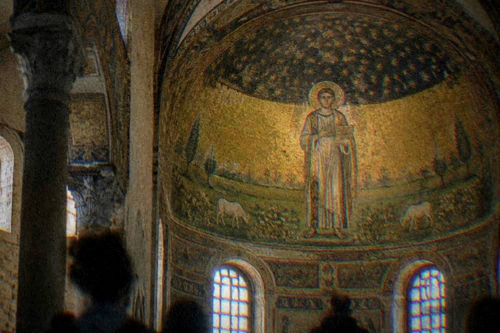 A gilded mosaic of a saint standing in a green meadow beneath a starry gold dome