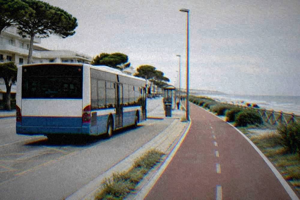 A regional bus parked at a seafront stop beside a cycle path