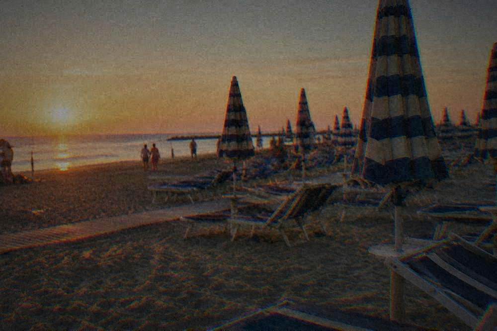 Rows of sunbeds and striped umbrellas on a managed summer beach