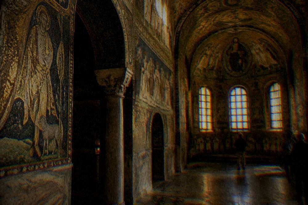 A gilded mosaic interior glowing under low light inside an ancient chapel