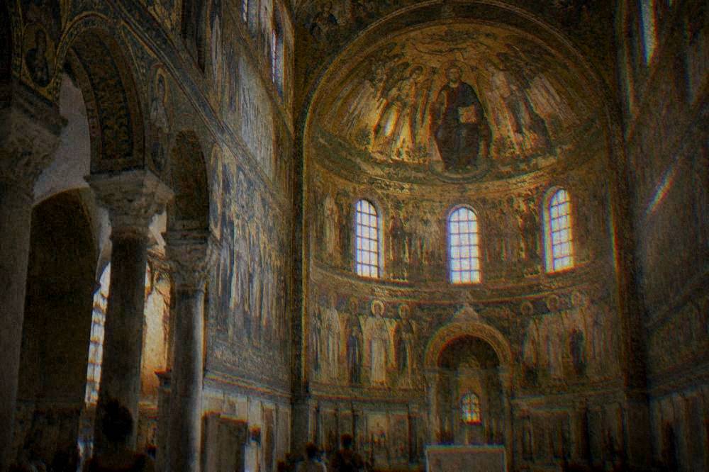 A golden interior of an ancient basilica covered in Byzantine mosaic decoration under a dome