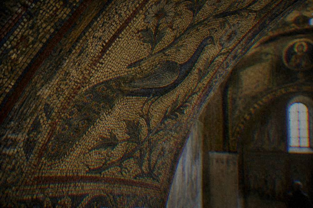 Close view of gold mosaic tesserae on a curved vault surface