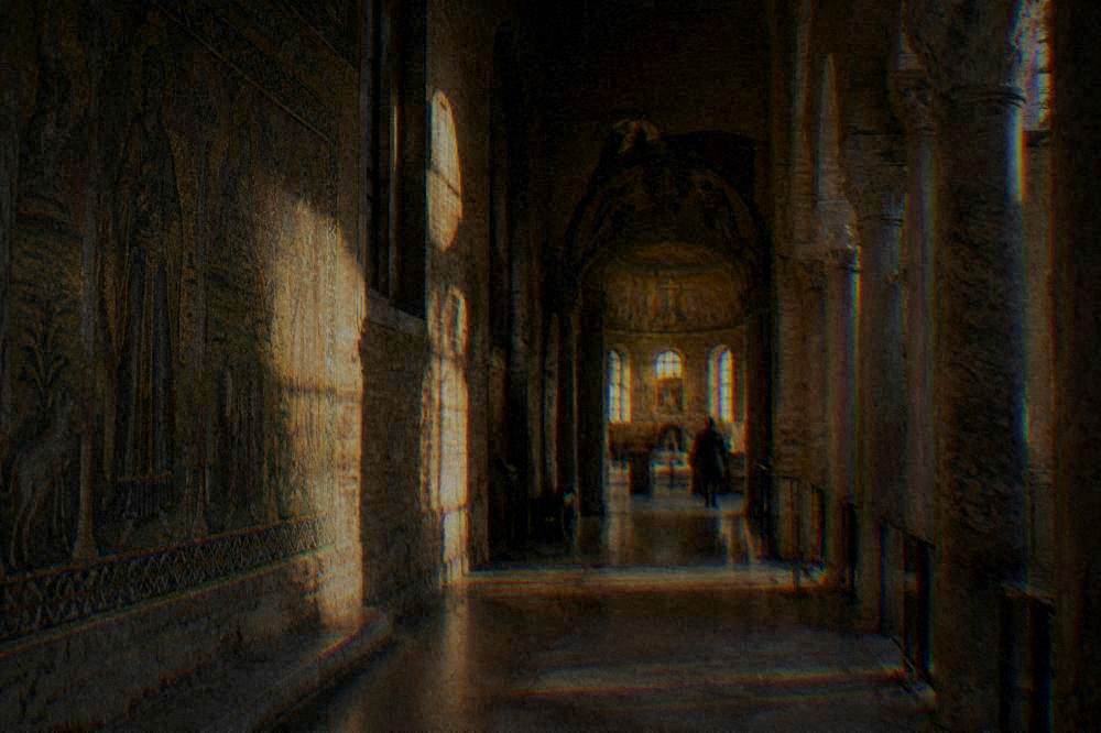 A museum corridor leading toward a chapel entrance with afternoon light