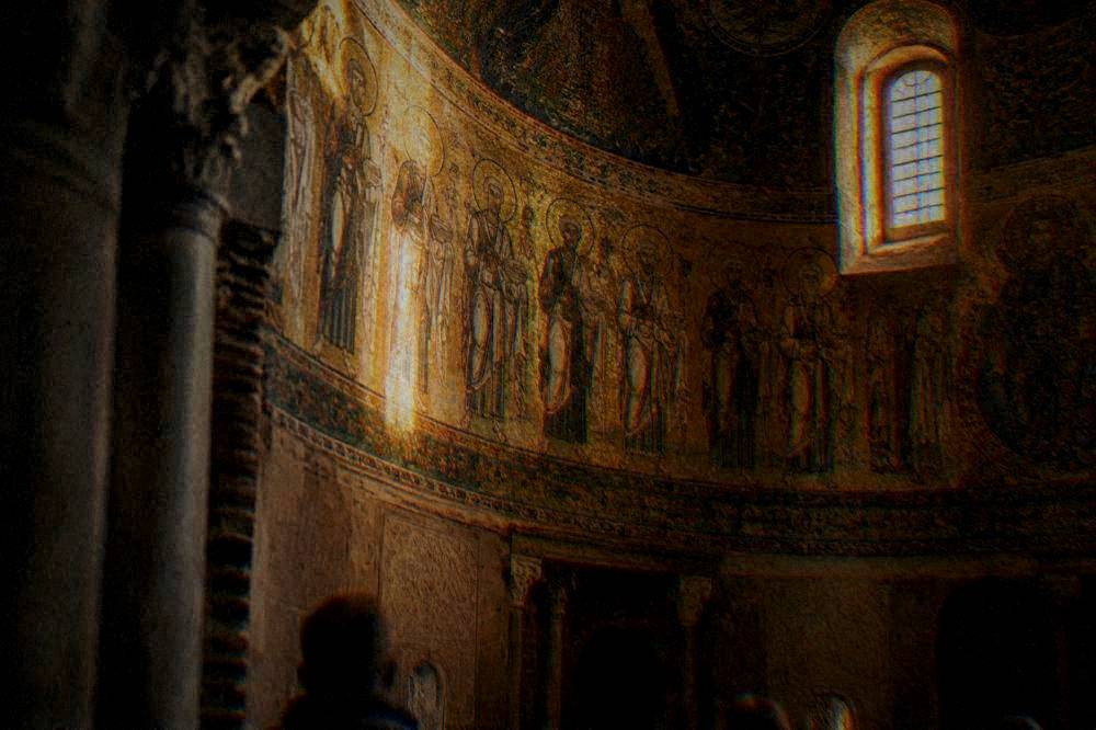 Upper wall mosaic of figures in gold ground inside a small chapel