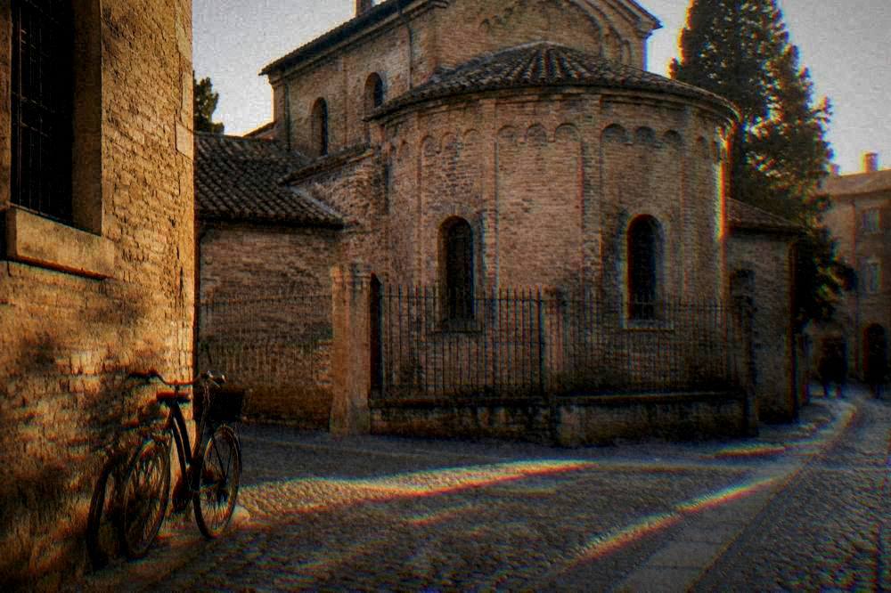 A quiet street corner with stone buildings and a bicycle leaning against a wall