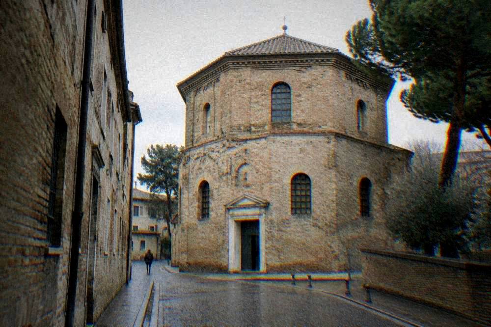Octagonal brick exterior of the Arian Baptistery seen from a quiet Ravenna street