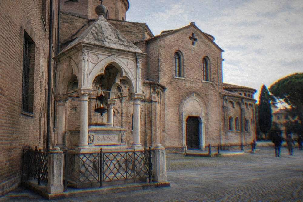 Dante's tomb beside the Basilica of San Francesco, a small stone monument with an eternal lamp