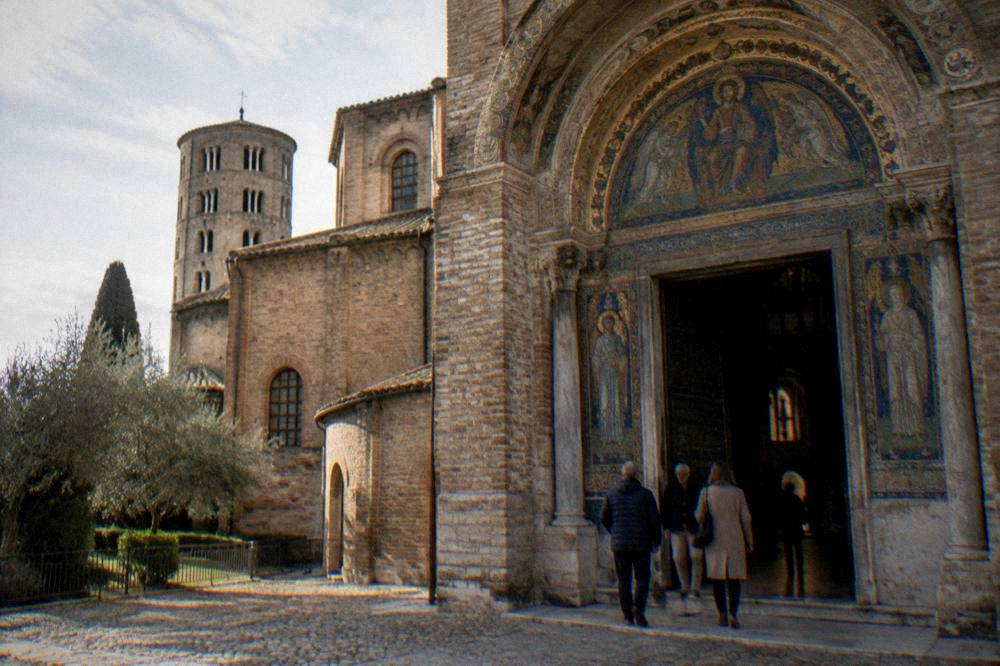 Guide speaking to a small group outside a mosaic church in Ravenna