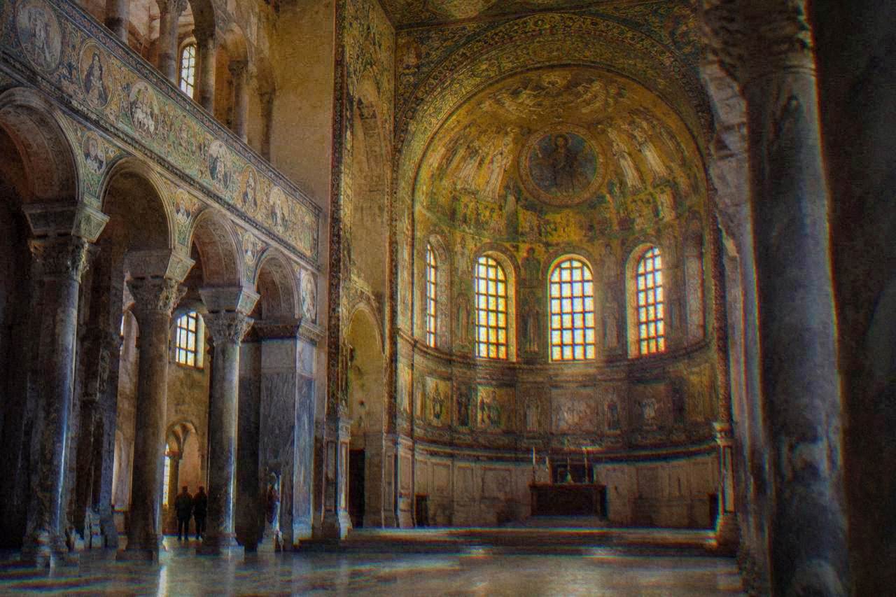 The octagonal interior of the Basilica of San Vitale with golden mosaic decoration in the apse and vault