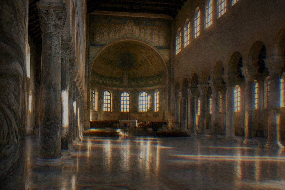 A wide interior view of a basilica nave with rows of stone columns and light falling on marble floors