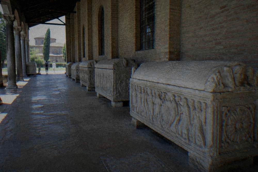 Carved stone sarcophagi lined up along the side wall of a basilica nave