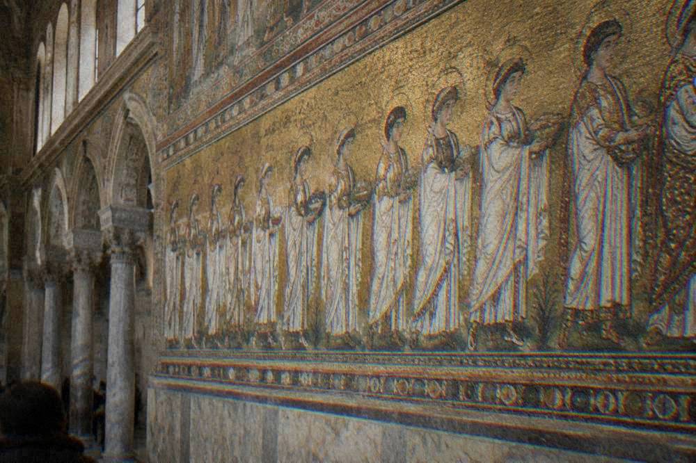 Gold mosaic detail of robed figures in a procession on a basilica wall