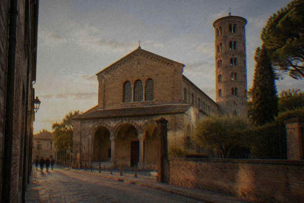 Brick exterior of a basilica seen from a street in Ravenna with a simple arched facade