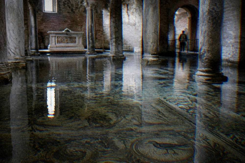 A flooded church crypt in Ravenna with clear water over an ancient mosaic floor