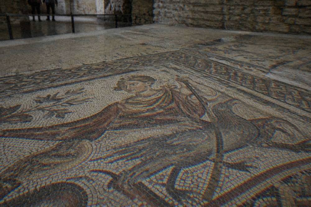 Close view of a mosaic panel with a figured design set among stone tesserae