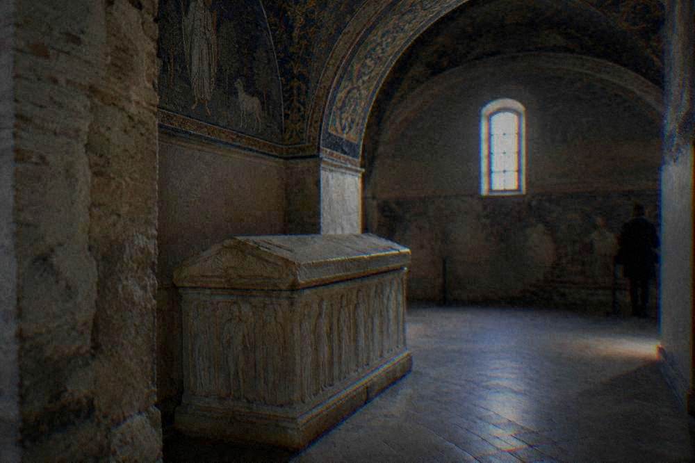 A stone sarcophagus standing in one arm of the small cruciform interior
