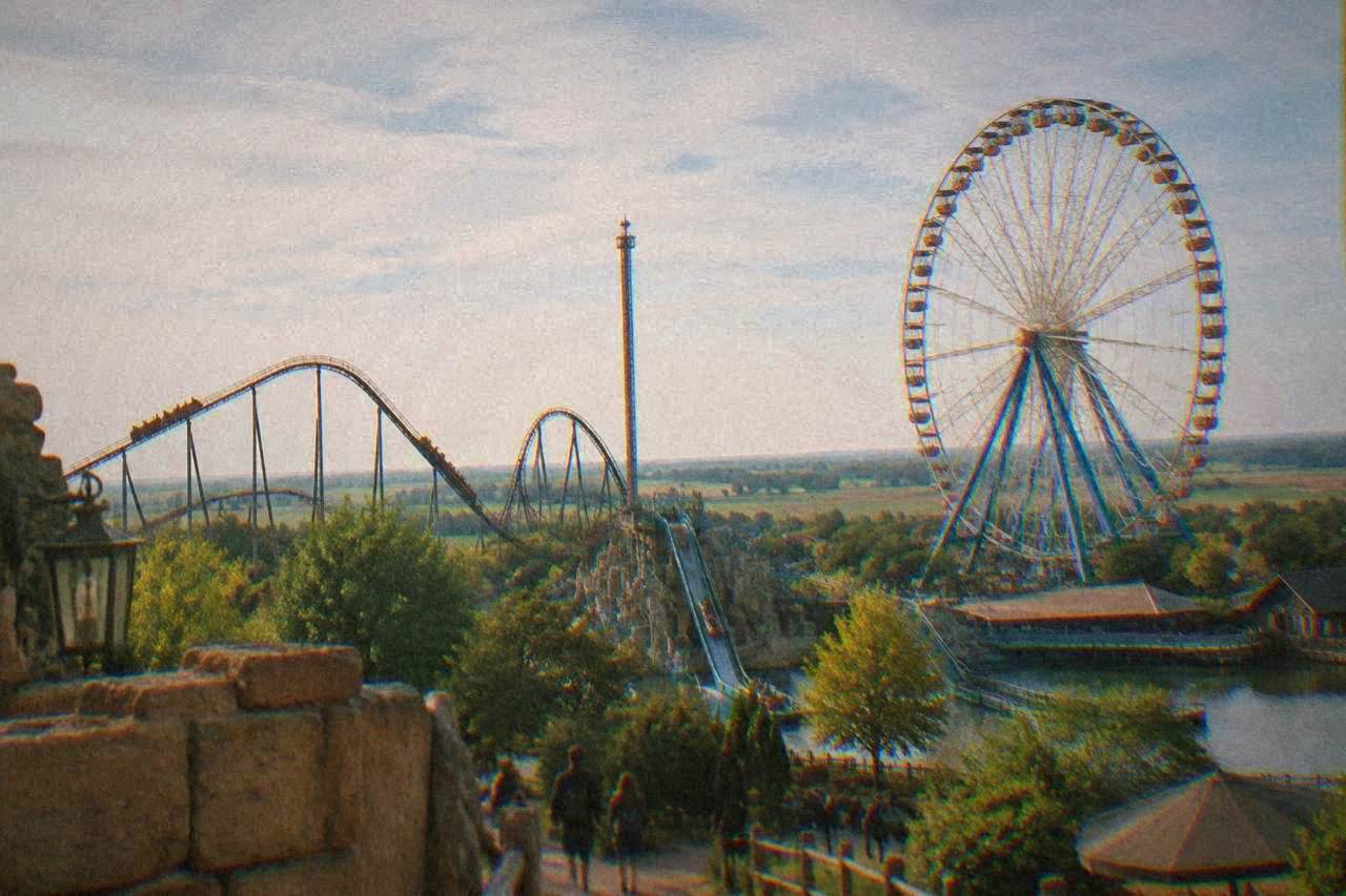 Ferris wheel and amusement park rides standing above a flat green plain near Ravenna