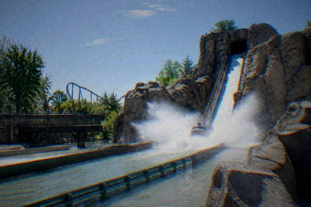 Water ride splash descending between rocks at an amusement park
