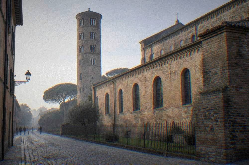The brick exterior wall of Sant'Apollinare Nuovo seen from a cobbled Ravenna street
