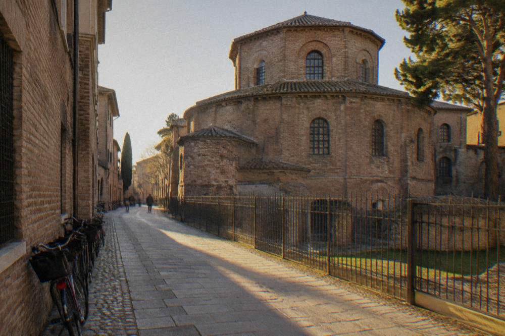 A quiet lane in Ravenna's historic centre lined with brick facades and bicycles